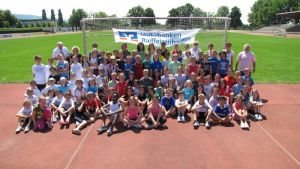 Gruppenfoto der sportlichen Grundschüler bei bestem Wetter im Sepp-Herberger-Stadion in Weinheim